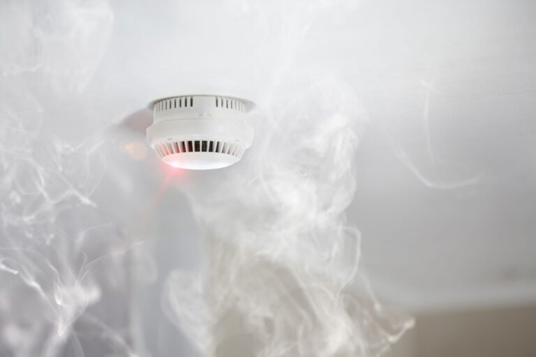 a cloud of smoke around fire alarm.