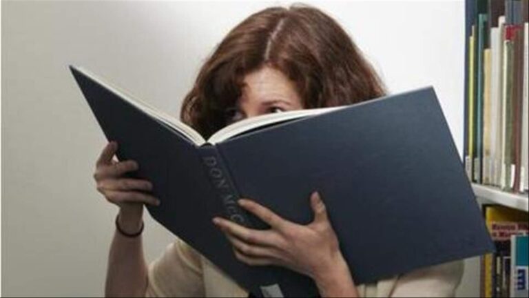 woman smelling book.